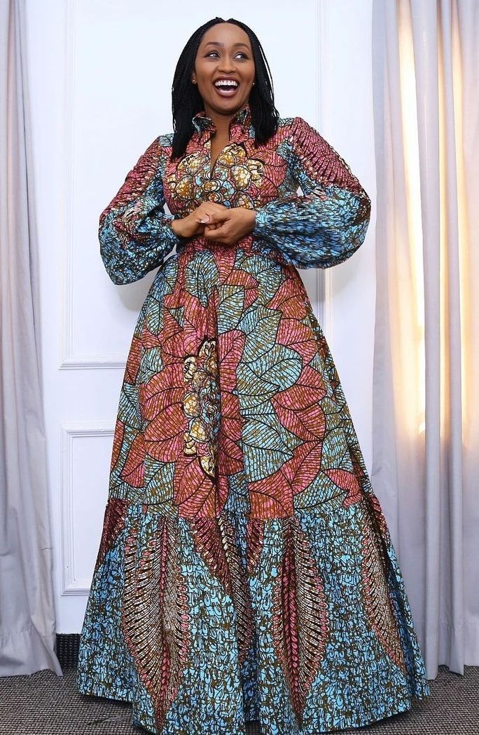 Robe longue en wax de la collection Korité d'Awa Couture, portée par une cliente souriante